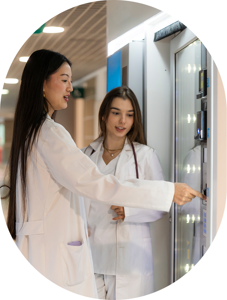 Two women in lab coats discussing device